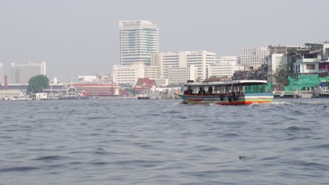 Ein-Schuss-Eines-Bootes,-Das-Auf-Dem-Geschäftigen-Und-Charmanten-Fluss-Der-Stadt-Bangkok-In-Der-Hauptstadt-Von-Thailand-In-Asien-Segelt
