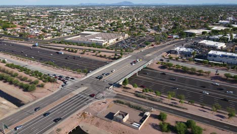 Drone-Panning-Around-a-busy-Highway-Junction-with-cars-getting-on-the-on-and-off-ramp-in-the-evening,-Highway-60-in-Arizona