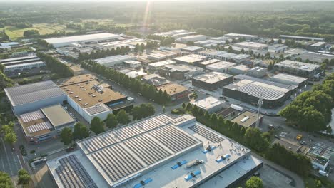 Aerial-overview-of-large-industrial-zone-with-solar-panels-on-building-rooftops-at-golden-hour