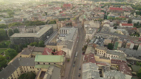 Aerial-birds-eye-shot-of-cars-driving-on-road-in-city-of-Krakow-during-early-morning-sunrays