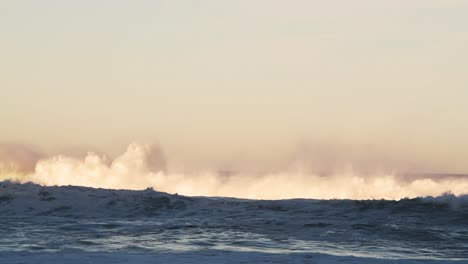 Olas-Oceánicas-Rompiendo-El-Fondo-En-La-Espectacular-Luz-Naranja-De-La-Puesta-De-Sol,-El-Mar-Rompiendo-Debajo-Del-Horizonte-Desde-Un-ángulo-Bajo-Con-Espacio-De-Copia