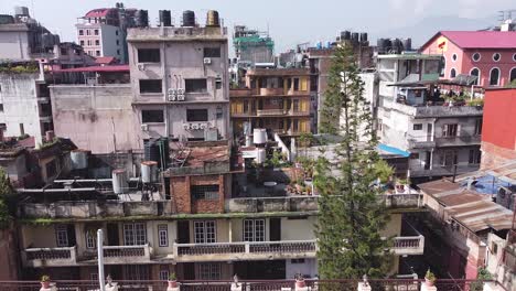 Drone-flying-low-over-tall-old-buildings-in-Katmandu,-Nepal