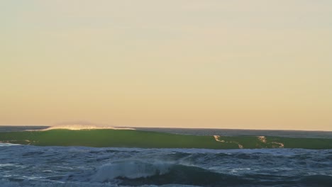 Ozeanwellen,-Die-Den-Hintergrund-In-Dramatischem-Orangefarbenem-Sonnenuntergangslicht-Brechen,-Das-Meer-Stürzt-Unter-Dem-Horizont-Aus-Einem-Niedrigen-Winkel-Mit-Kopierraum-Ab-1