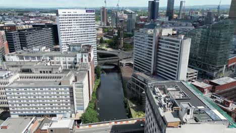 Aerial-Drone-Flight-over-the-River-Irwell-in-Manchester-City-Centre-showing-the-surrounding-rooftops-and-buildings-below