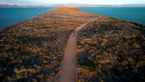 Drone-shot-of-a-car-crossing-the-dunes-of-mogote-in-La-Paz-Baja-California-Sur-Mexico