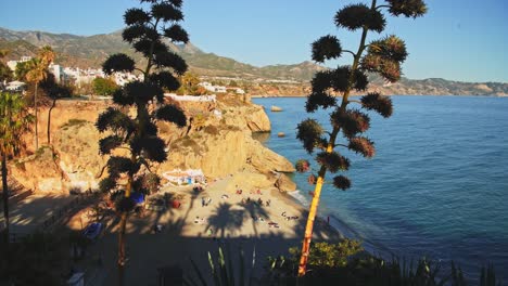 Aerial-Drone-View-of-Beautiful-Beach-on-Mediterranean-Coast-of-Spain-at-Nerja,-Costa-Del-Sol-in-Andalusia-,-Mountains-and-Blue-Ocean-Sea-Water-on-Sunny-Day-With-Clear-Blue-Sky-in-Europe