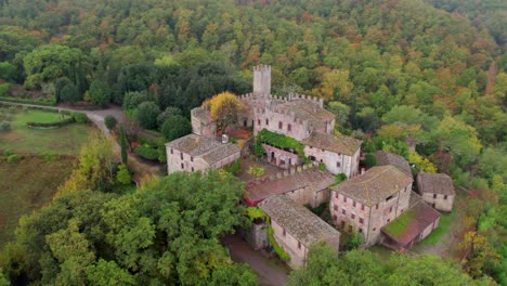 Castle-of-Montalto-on-hill-surrounded-by-woodland,-cloudy-day,-aerial