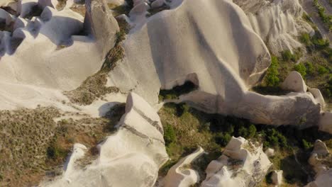 Volando-Sobre-Formaciones-Rocosas-Marrones-Y-Blancas-Naturales-Y-Revelando-Tierras-De-Cultivo-En-Capadocia,-Turquía