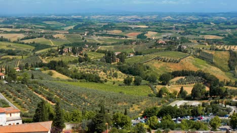 Drone-Volando-Hacia-El-Paisaje-Con-Viñedos-Y-Bodega-En-Un-Día-Soleado-En-San-Gimignano,-Toscana,-Italia