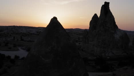 Magical-golden-hour-sunset-in-Cappadocia-turkey-while-drone-rotates-around-natural-rock-formation-fairy-chimney