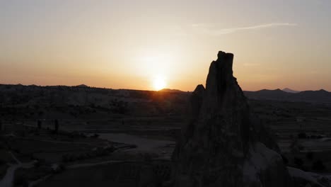 Flying-drone-up-along-fairy-chimney-rock-formation-by-beautiful-golden-sunset-over-mountain-Cappadocia-turkey