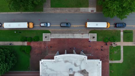 Top-down-aerial-of-school-students-and-busses-lined-up