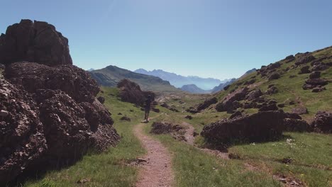 Back-view-of-hiker-running-down-trail-in-Spanish-Pyrenees-during-summer-early-morning