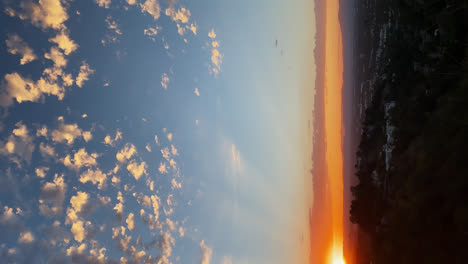 Tiro-Vertical-De-La-Hermosa-Puesta-De-Sol-Con-Sol-Dorado-Contra-El-Cielo-Azul-Sobre-Los-ángeles-En-California-1