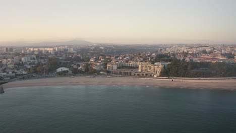 Aerial-view-of-Santo-amaro-beach-of-Oeiras,-sunset-in-Portugal---drone-shot-In-Silhouette-Mood