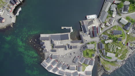 Top-down-shot-of-the-famous-village-and-harbor-in-Hamnoy,-Lofoten-Island-on-a-sunny-day-with-breakwater-wall