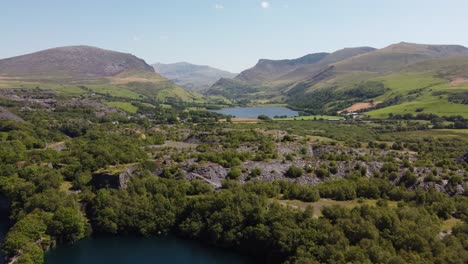 Aerial-view-flying-above-Snowdonia-valley-Dorothea-quarry-woodland-landscape