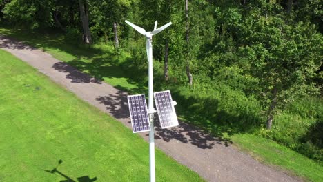 Park-pole-mounted-with-solar-panels-and-windmill-to-generate-energy,-aerial-orbit-view