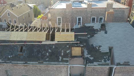 Aerial-drone-shot-from-right-to-left-over-a-burned-roof-house-on-a-bright-sunny-day