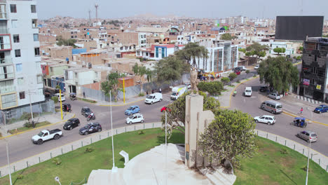 Beautiful-drone-shot-over-the-famous-"Ovalo-QuiÃ±ones"-oval-on-the-highway-of-the-city-of-Chiclayo,-Peru-while-cars-drive-around-during-the-afternoon