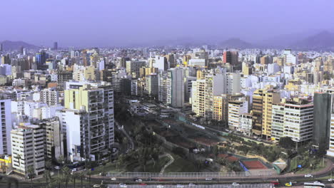Beautiful-zoom-in-drone-shot-of-the-Miraflores-district-in-Lima,-Peru-in-the-morning-hour-with-buildings-in-the-city
