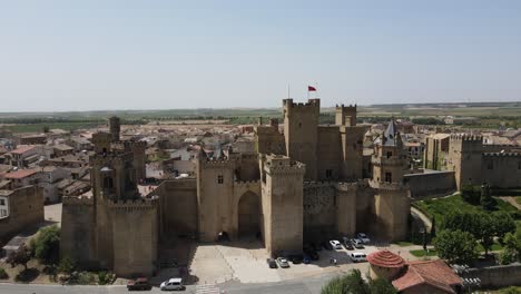 Stunning-Olite-Castle-with-flag-flying-on-a-warm-sunny-day,-dolly-right
