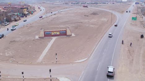 Aerial-long-shot-with-drone-of-the-entrance-to-the-city-of-Chiclayo-in-Peru-while-cars-pass-around-on-the-highway
