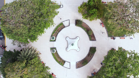 Amazing-and-beautiful-drone-zoom-out-of-a-circular-park-with-trees-in-the-city-of-Chiclayo,-Peru-during-the-day