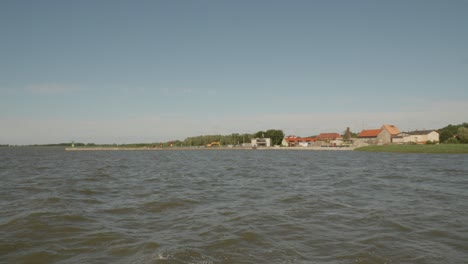 Distant-View-Of-Coastal-Town-Of-Frombork-Across-The-Vistula-Lagoon-In-Braniewo-County,-Poland