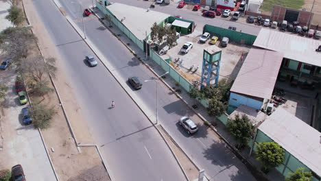 Amazing-aerial-drone-shot-following-a-car-along-the-famous-"Panamericana-Norte"-highway-in-Chiclayo,-Peru-in-the-morning