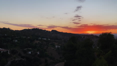 Vistas-A-La-Montaña-De-La-Puesta-De-Sol-Detrás-De-Las-Líneas-Montañosas-Con-Casas-Contra-El-Cielo-Azul-Con-Nubes-En-Los-ángeles,-California