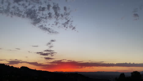 Silueta-De-Montañas-A-Lo-Largo-Del-Horizonte-Justo-Después-De-Que-El-Sol-Se-Ha-Puesto-Y-El-Cielo-Es-Azul-Y-Rojo-En-Los-ángeles,-California