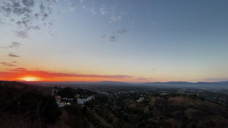 Mountain-View-Of-The-Sun-Setting-Behind-Mountains-Against-Blue-Sky-With-Clouds-In-Los-Angeles-Suburb-below-hiking-trail,-California