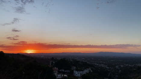 Mountain-View-Of-The-Sun-Setting-Behind-Mountains-Against-Blue-Sky-With-Clouds-In-Los-Angeles-on-a-hiking-trail,-California