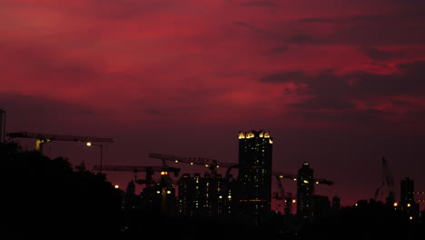 Urban-development-in-Hong-Kong,-twilight-sky-construction-cranes-silhouette