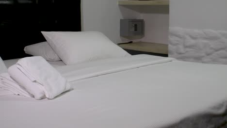 Track-Shot-Of-A-artistic-Hotel-Room-Interior,-DETAILS-white-TOWELS-and-safe,-PAN-LEFT