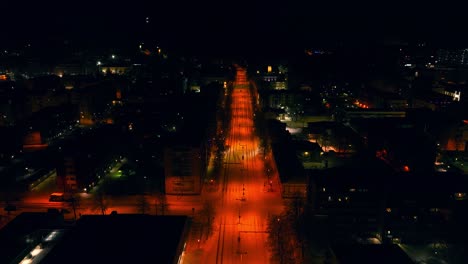 Aerial-view-over-the-illuminated-streets-of-Kuopio,-winter-night-in-Finland---reverse,-drone-shot