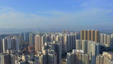 Filmische-Drohnenaufnahme,-Die-Tagsüber-über-Einem-Vorort-Von-Hongkong-Nach-Oben-Wandert-Und-Die-Ferne-Stadt-Shenzhen-Enthüllt