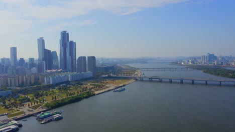 Drone-shot-traveling-forward-above-the-Han-river-toward-the-Mapo-bridge-and-a-business-district-with-skyscrapers-in-Seoul-city-during-the-day-1