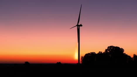 Silhouette-of-the-rotating-propellers-of-a-wind-turbine-at-sunset