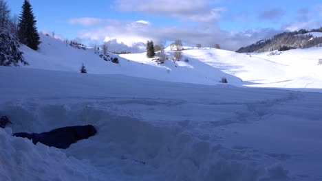 Person-Digging-a-Pile-of-Snow-from-the-Inside-and-Tossing-Snow-Outside-on-a-Clear-Day-in-the-Alps