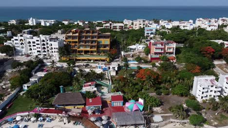 Aerial-drone-forward-moving-shot-over-Isla-Mujeres-island-with-beach-clubs-and-resorts-in-Quintana-Roo-Mexico-on-a-bright-sunny-day