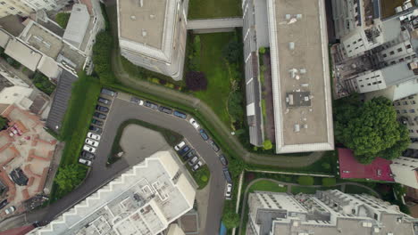 Apartment-buildings-and-courtyards-with-car-parking-lots,-low-aerial-view