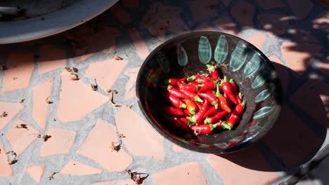 Small-red-chili-pods-drop-into-tiny-bowl