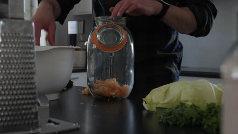 Llenando-Un-Frasco-De-Vidrio-Con-Zanahoria,-Proyecto-De-Fermentación-Vegetal-De-Bricolaje-En-Casa,-Muñequita