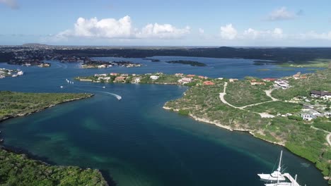 Aerial-view-of-island-with-boats-and-mountains-golf-court-ocean-view-sail-boats-marina