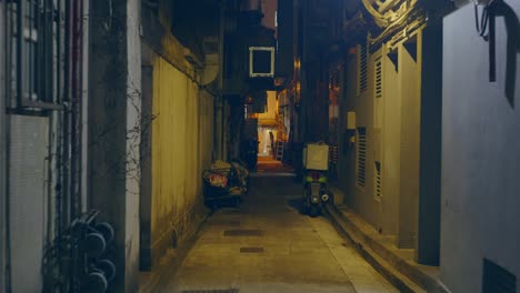 Traveling-shot-in-a-dark-small-narrow-empty-street-in-the-night-in-a-city