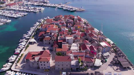 Picturesque-Tribunj-island-with-historic-houses-and-boats-at-harbor,-aerial