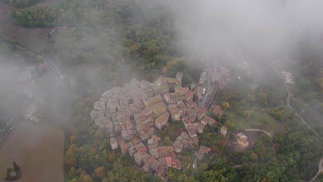 Above-clouds-with-visible-medieval-town-San-Casciano-dei-Bagni,-aerial