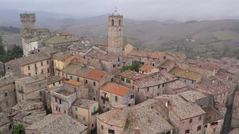 Picturesque-medieval-Italian-town-on-hill-top-overlooking-rural-landscape-during-cloudy-day